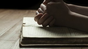 Praying Hands over Scripture